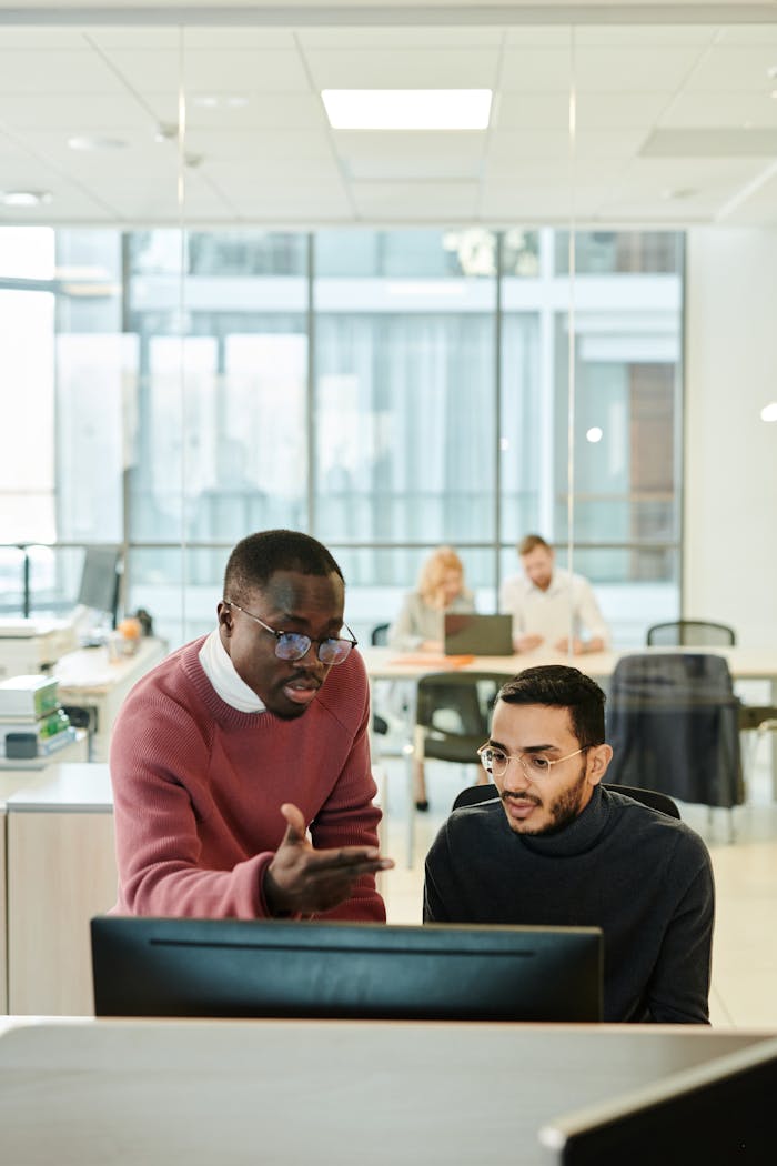 Diverse colleagues brainstorming and working together at a desk in a modern office setting.
